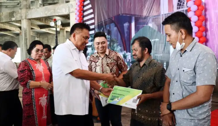 Gubernur Provinsi Sulawesi Utara, Olly Dondokambey secara simbolik menyerahkan BPJS Ketenagakerjaan kepada pegawai gereja. Istimewa