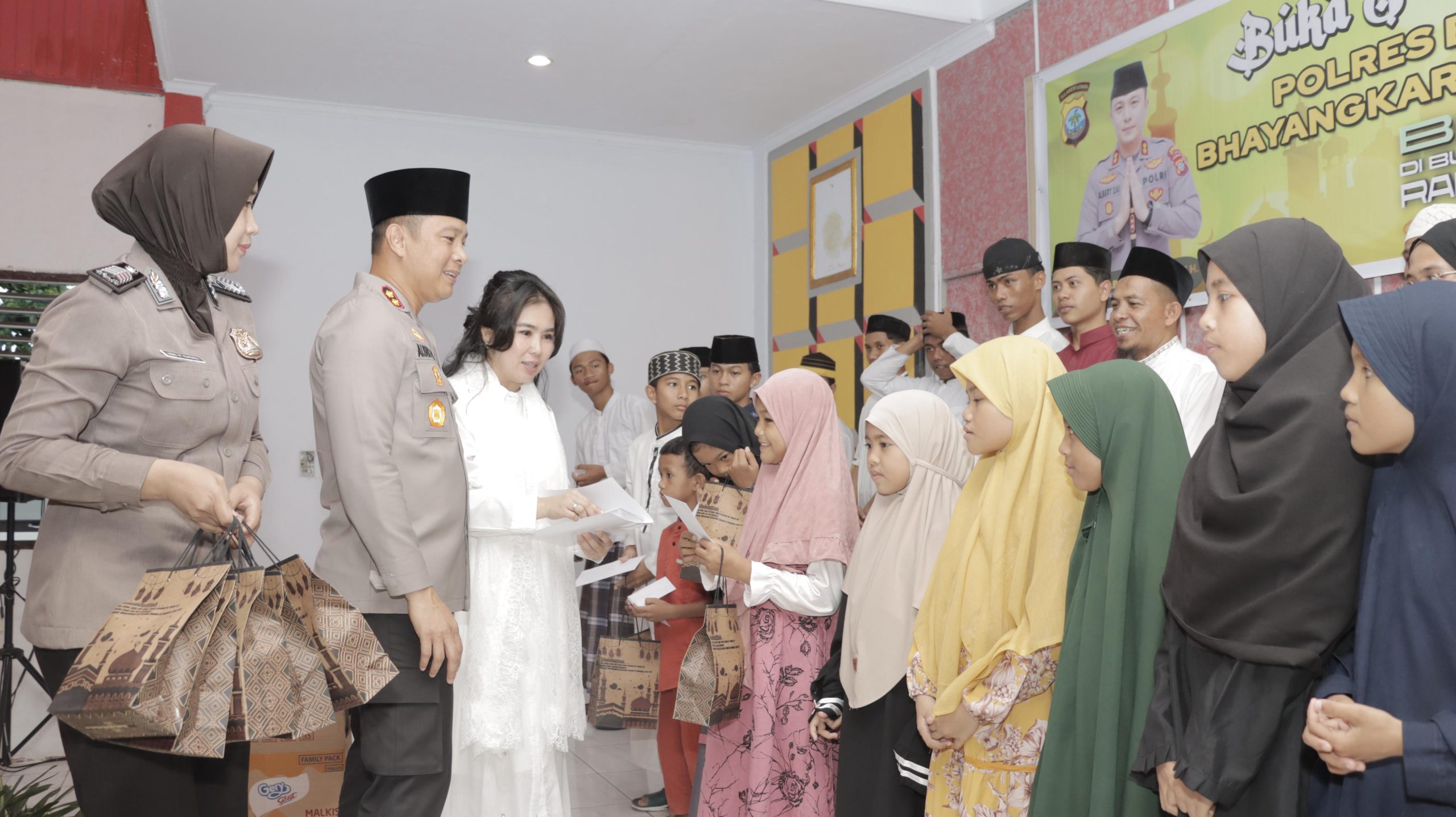 Kapolres Bitung AKBP Albert Zai bersama Ny. Detta Albert Zai memberikan santunan kepada para Anak Yatim saat gelar buka puasa bersama Polres Bitung. (Foto: Humas Polres Bitung)