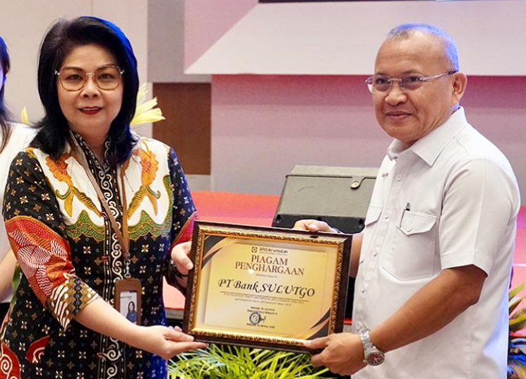 Kepala BPJS Kesehatan Cabang Utama Manado, drg. Betsy Roeroe, AAAK., menyerahkan Piagam Penghargaan kepada Direktur Umum Bank SulutGo, Bapak Joubert Dondokambey. (Foto: BSG)