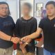 Terduga pelaku AT diapit dua personel Polres Bitung. (Foto: Istimewa)