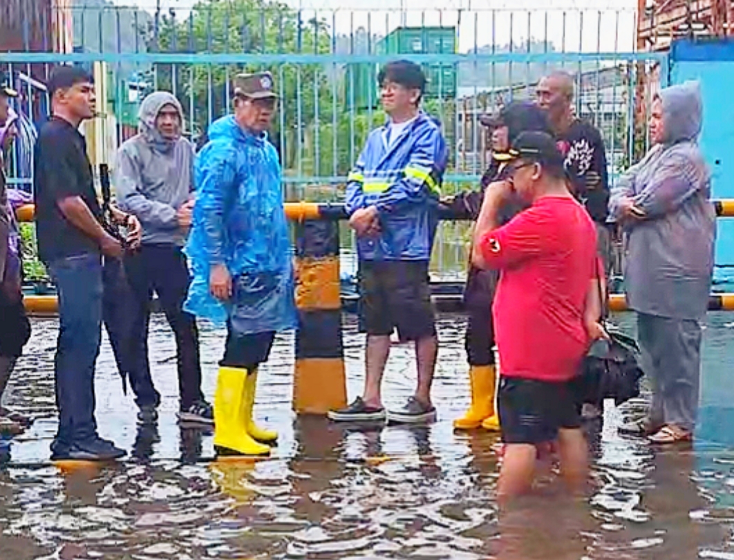 Walikota Bitung, Hengky Honandar SE (mantel biru) saat meninjau titik lokasi banjir. (Foto:Istimewa)