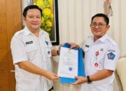 Sekretaris Daerah (Sekda) Kota Bitung, Ir. Ign Rudy Theno ST MT MAP (kanan) saat menyerahkan SK Walikota Bitung kepada Altin Tumengkol SIP, M.Si,(kiri) sebagai Pelaksana Tugas (Plt) Kepala Dinas Komunikasi dan Informatika (Kominfo) Kota Bitung. (Foto: Istimewa)