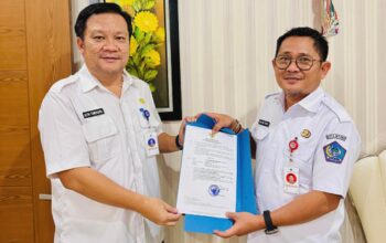 Sekretaris Daerah (Sekda) Kota Bitung, Ir. Ign Rudy Theno ST MT MAP (kanan) saat menyerahkan SK Walikota Bitung kepada Altin Tumengkol SIP, M.Si,(kiri) sebagai Pelaksana Tugas (Plt) Kepala Dinas Komunikasi dan Informatika (Kominfo) Kota Bitung. (Foto: Istimewa)