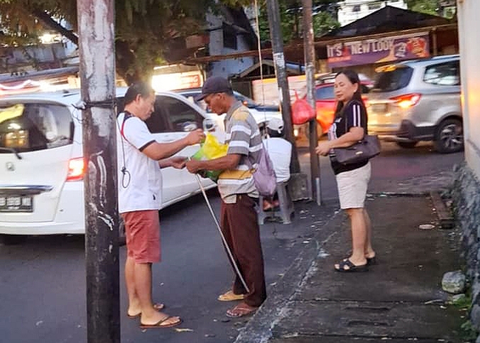 Erwin Wagei terlihat menyerahkan bingkisan kasih Natal bersama Sang Istri tercinta, Hetty Tumanduk.