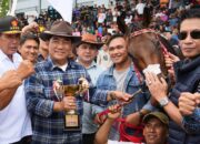 Gubernur Sulawesi Utara, Yulius Selvanus memegang trofi bersama Sang Juara, kuda Gadis Tondano miliknya di ajang Kejuaraan Pacuan Kuda New Year 2026 Tompaso.