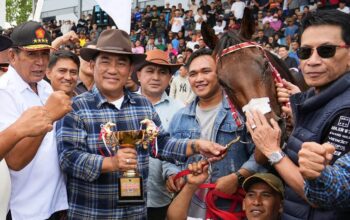 Gubernur Sulawesi Utara, Yulius Selvanus memegang trofi bersama Sang Juara, kuda Gadis Tondano miliknya di ajang Kejuaraan Pacuan Kuda New Year 2026 Tompaso.