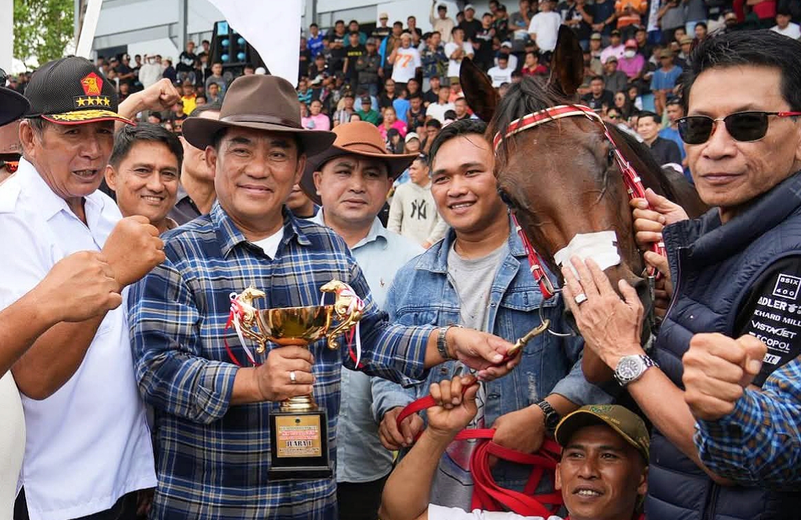 Gubernur Sulawesi Utara, Yulius Selvanus memegang trofi bersama Sang Juara, kuda Gadis Tondano miliknya di ajang Kejuaraan Pacuan Kuda New Year 2026 Tompaso.