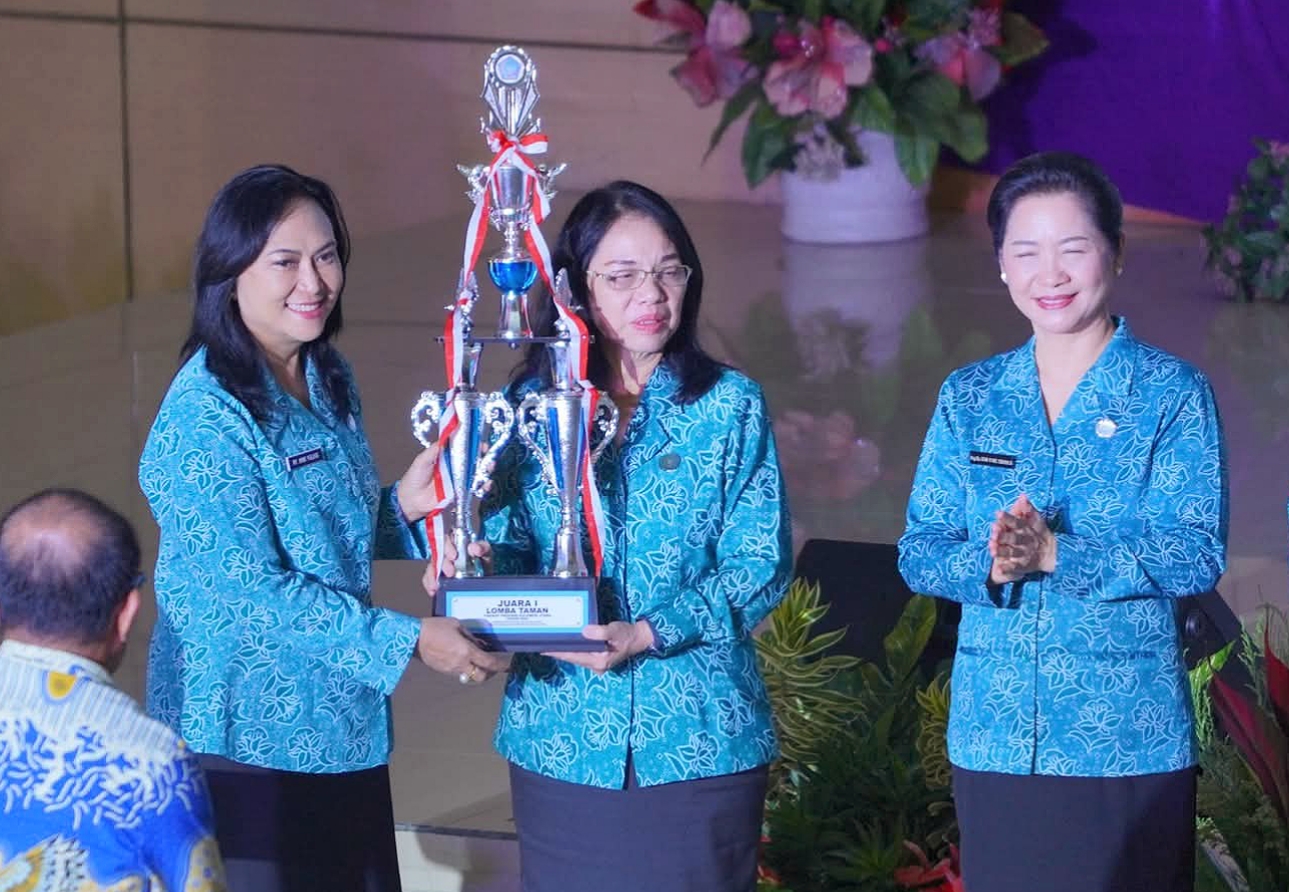 Ketua TP PKK Bitung, Ny. Ellen Honandar Sondakh SE, saat menerima trofi juara umum lomba PKK Sulut 2025 dari Ketua TP PKK Sulut, Ny. Anik Yulius Selvanus. (Foto: Ist)