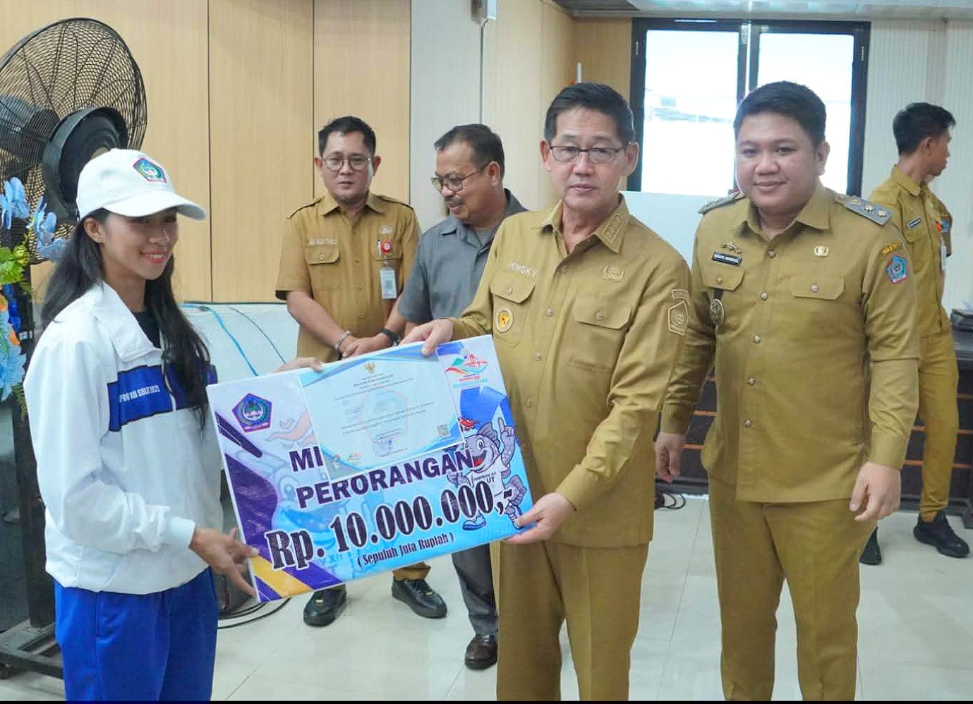 Walikota Bitung Hengky Honandar SE dan Wakil Walikota Randito Maringka S.Sos (HH-RM), saat menyerahkan secara simbolis bonus Atlet, Pelatih dan Official yang berprestasi di ajang olahraga Porprov XII Sulut. (Foto: Istimewa)