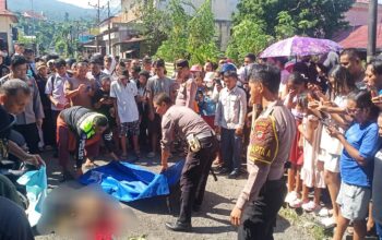WASPADA JALAN BERPASIR: Suasana evakuasi korban kecelakaan di Jalan Pateten Dua, Bitung. Insiden ini dipicu kondisi aspal yang tertutup material pasir, menyebabkan penumpang motor terjatuh dan tertabrak truk dari arah berlawanan. (Foto: Istimewa/Dok.SUDARA.ID)