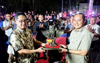 Walikota Bitung, Hengky Honandar SE (kiri), menyerahkan Kriya Burung Manguni kepada Kapolres AKBP Albert Zai SIK MH sebagai tanda penganugerahan gelar “Bapak Perdamaian Kota Bitung”, Sabtu (25/4/2026). Penghargaan ini merepresentasikan kearifan kepemimpinan dalam menjaga harmoni di Kota Cakalang. (Foto: Dok. Istimewa)