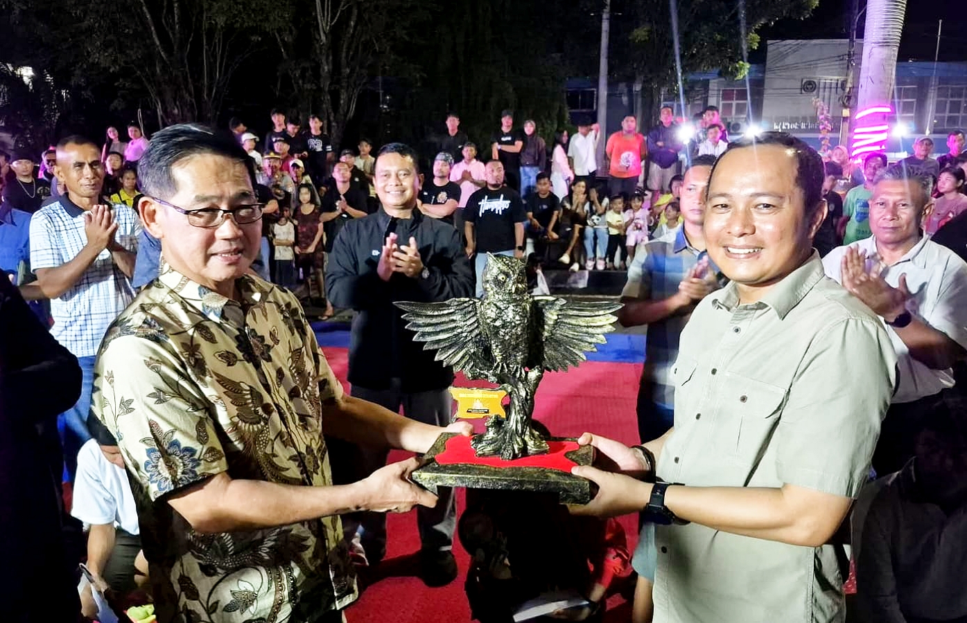 Walikota Bitung, Hengky Honandar SE (kiri), menyerahkan Kriya Burung Manguni kepada Kapolres AKBP Albert Zai SIK MH sebagai tanda penganugerahan gelar “Bapak Perdamaian Kota Bitung”, Sabtu (25/4/2026). Penghargaan ini merepresentasikan kearifan kepemimpinan dalam menjaga harmoni di Kota Cakalang. (Foto: Dok. Istimewa)