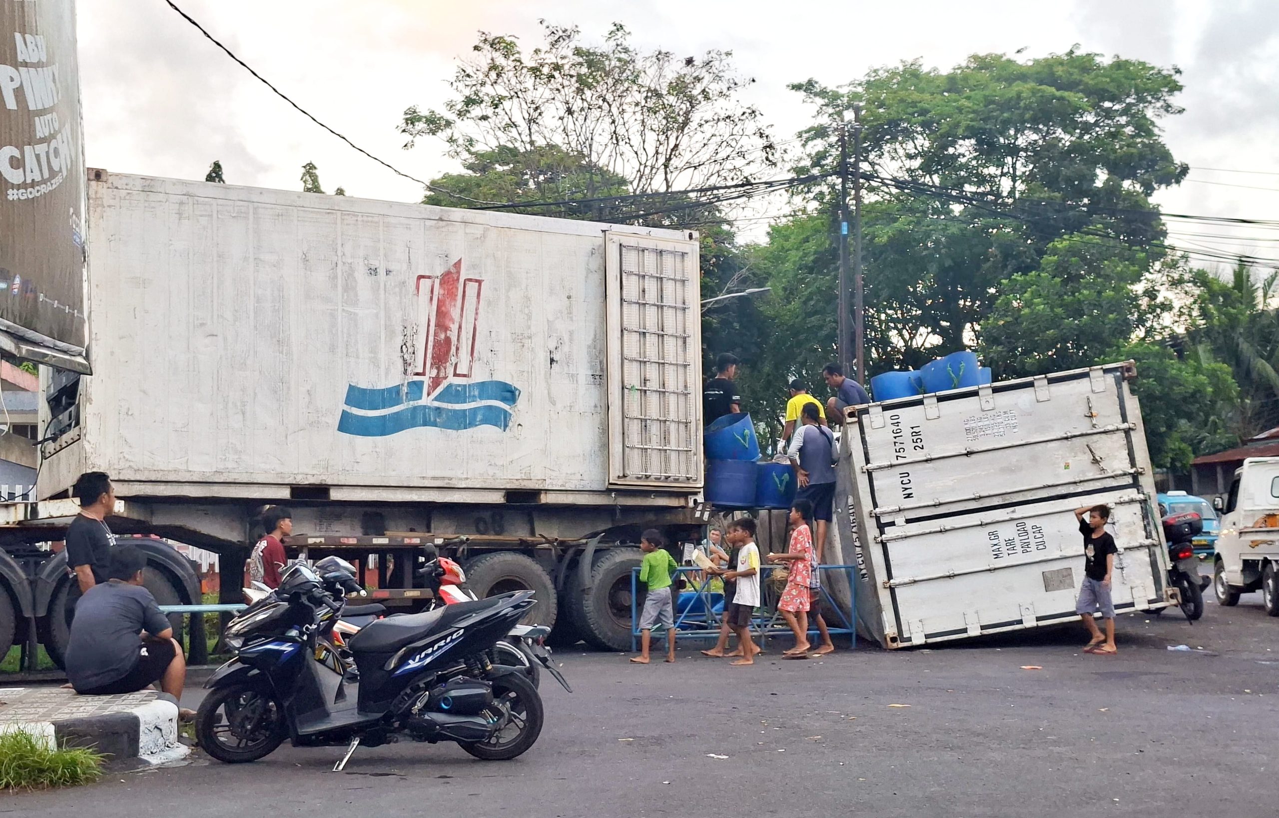 Satu unit kontainer bermuatan ikan segar terjatuh di Jalan Yos Sudarso, Bitung, akibat gandengan truk yang patah, Minggu (3/5/2026). (Foto: Istimewa)