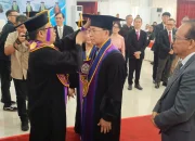 Rektor Berty Sompie saat melakukan prosesi pemakaian toga kepada Prof. Steenie Wallah dalam Sidang Senat Terbuka Universitas Sam Ratulangi. Momen ini menjadi puncak perjuangan akademik Prof. Steenie yang membawa inovasi Beton Geopolimer sebagai solusi konstruksi masa depan yang ramah lingkungan. (Foto: Ridho L Tobing)