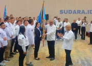 Ketua Umum PWI Pusat Akhmad Munir menyerahkan pataka organisasi kepada Ketua PWI Sulut terpilih Sintya Bojoh pada prosesi pelantikan di Hotel Sintesa Peninsula, Manado, Rabu (13/5/2026). (Foto: Ridho L Tobing)