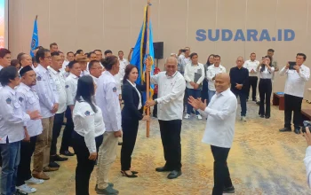 Ketua Umum PWI Pusat Akhmad Munir menyerahkan pataka organisasi kepada Ketua PWI Sulut terpilih Sintya Bojoh pada prosesi pelantikan di Hotel Sintesa Peninsula, Manado, Rabu (13/5/2026). (Foto: Ridho L Tobing)