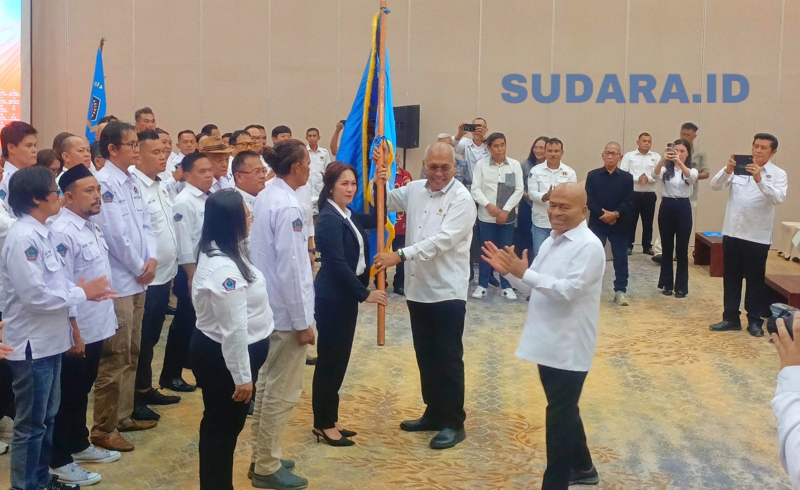 Ketua Umum PWI Pusat Akhmad Munir menyerahkan pataka organisasi kepada Ketua PWI Sulut terpilih Sintya Bojoh pada prosesi pelantikan di Hotel Sintesa Peninsula, Manado, Rabu (13/5/2026). (Foto: Ridho L Tobing)