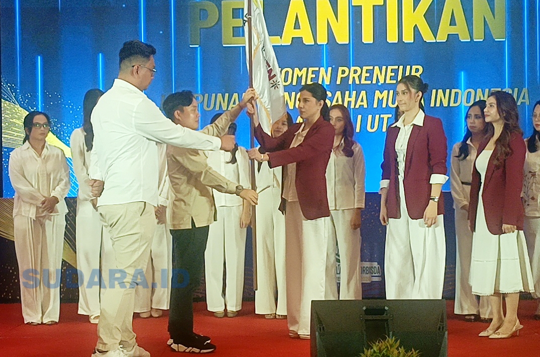 Ketua BPD Hipmi Sulut, Hizkia Sembel (kiri), menyerahkan pataka kepada Hillary Julia Tuwo (kanan) saat pengukuhan Hipmi Womenpreneur Sulut di Manado, Jumat (1/5/2026). (Foto: Ridho L Tobing)