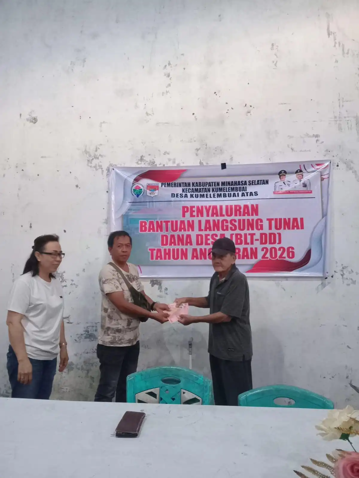 Penjabat Hukum Tua Desa Kumelembuai Atas Jans Lazarus Liando SE saat menyerahkan BLT DD Tahap 1 Tahun 2026. Foto 1