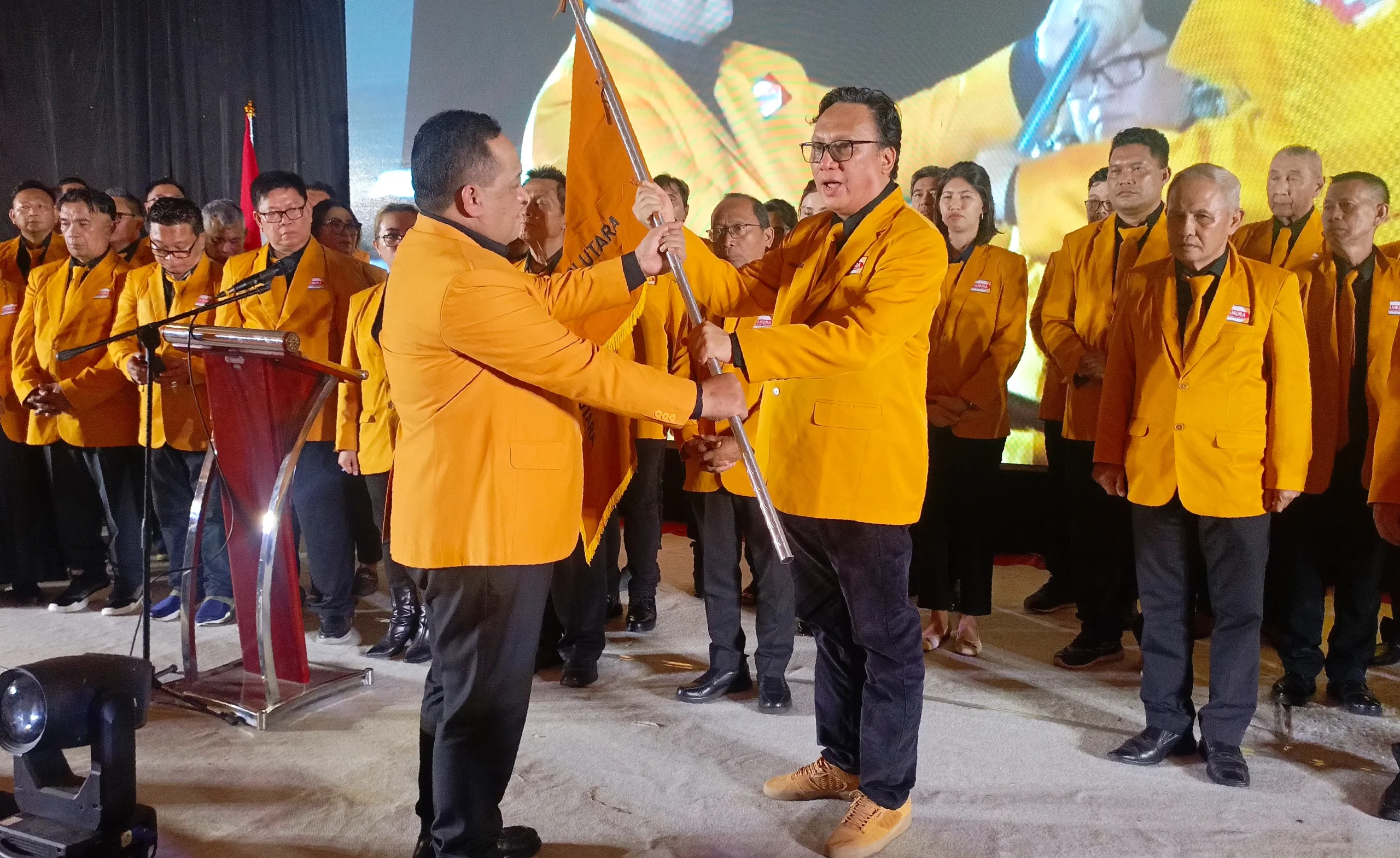 Apriano Ade Saerang saat menerima pataka Partai Hanura dari Sekjen DPP Benny Rhamdani. Mandat 2026-2031 ini menandai dimulainya gerakan 'Auman Singa' Hanura hingga ke akar rumput Sulawesi Utara.