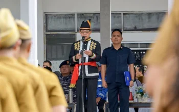 Walikota Bitung Hengky Honandar, S.E., saat menyampaikan pidato menteri mengenai pentingnya peran ayah mengasuh anak pada Upacara Harganas ke-33 di Lapangan Kantor Walikota, Senin (29/6/2026). (Foto: Istimewa)