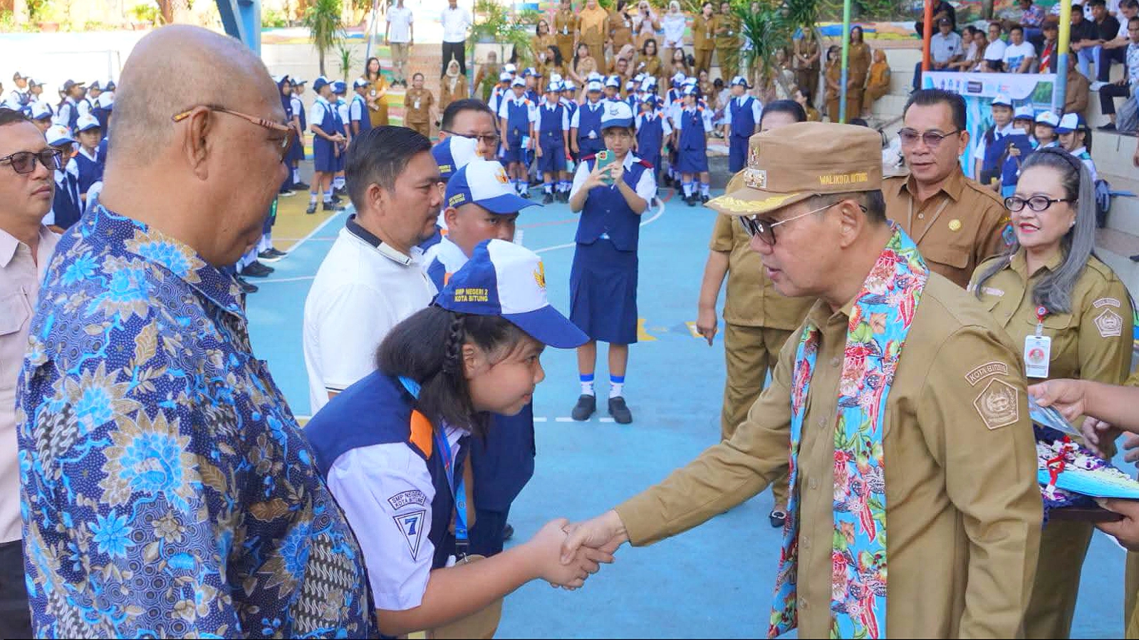 Cermin generasi berakhlak mulia: Seorang siswi baru dengan gestur sopan menerima salam hangat dari Walikota Hengky Honandar saat pembukaan MPLS TA 2026/2027 di SMPN 2 Bitung. (Foto: Istimewa)