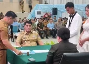 Gubernur Sulawesi Utara, Yulius Selvanus Komaling, saat menjadi saksi dan menyerahkan dokumen kependudukan secara simbolis pada acara Pencatatan Perkawinan Massal Pemprov Sulut di Aula Mapalus, Manado, Selasa (21/7/2026). (Foto: Istimewa)