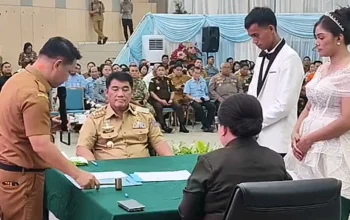 Gubernur Sulawesi Utara, Yulius Selvanus Komaling, saat menjadi saksi dan menyerahkan dokumen kependudukan secara simbolis pada acara Pencatatan Perkawinan Massal Pemprov Sulut di Aula Mapalus, Manado, Selasa (21/7/2026). (Foto: Istimewa)