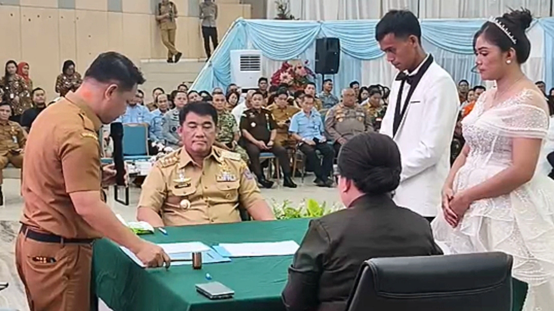 Gubernur Sulawesi Utara, Yulius Selvanus Komaling, saat menjadi saksi dan menyerahkan dokumen kependudukan secara simbolis pada acara Pencatatan Perkawinan Massal Pemprov Sulut di Aula Mapalus, Manado, Selasa (21/7/2026). (Foto: Istimewa)