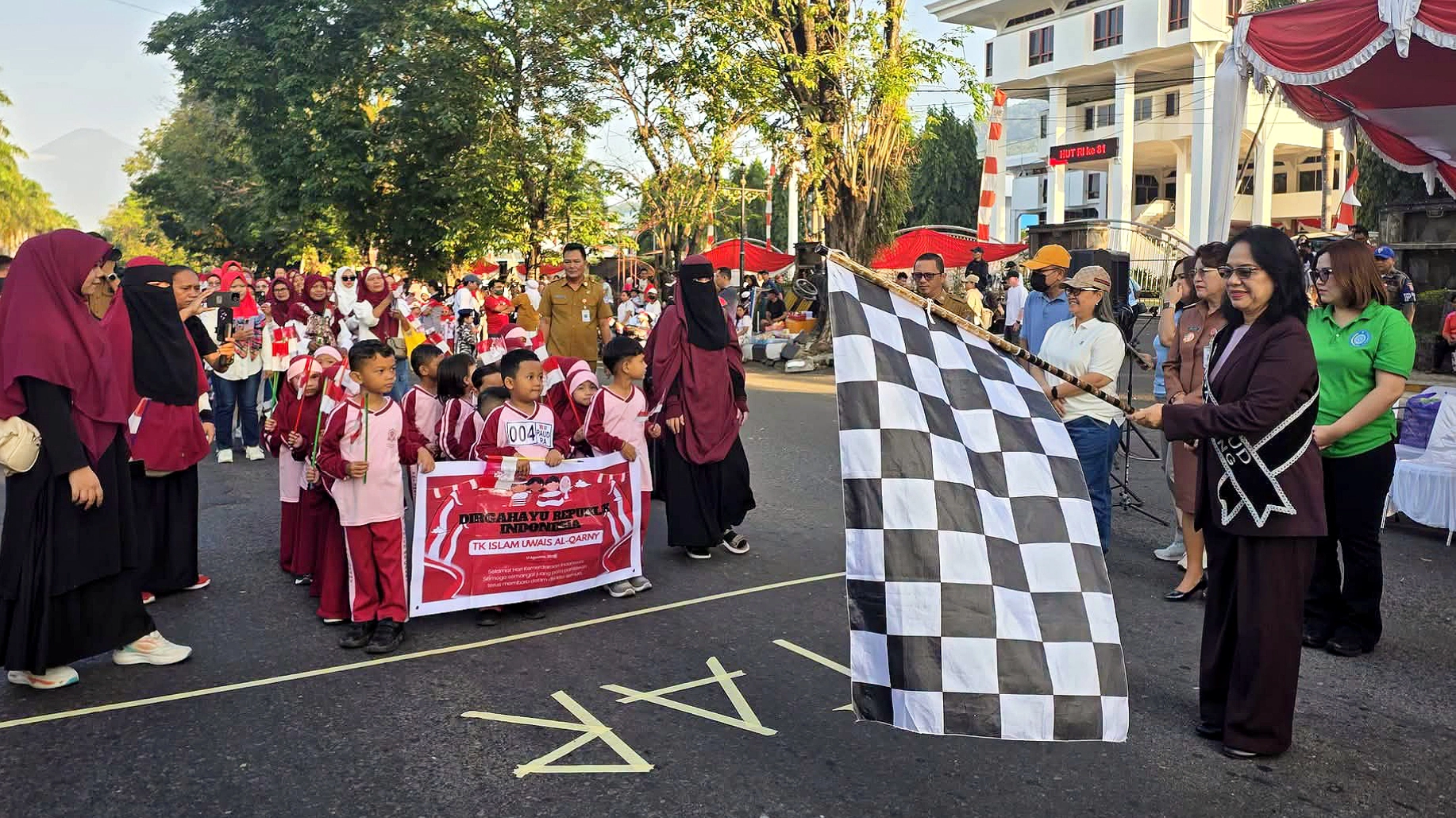 Bunda PAUD Kota Bitung, Ny. Ellen Honandar Sondakh, S.E., bersiap mengibarkan bendera start untuk melepas peserta Lomba Gerak Jalan TK/PAUD se-Kota Bitung di depan Kantor Wali Kota Bitung, Senin (10/8/2026). (Foto: Istimewa)