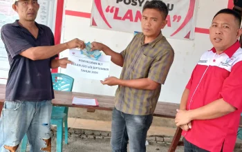 Penjabat Hukum Tua Desa Kumelembuai Satu Rivo Mongkaren SE saat menyerahkan BLT ke salah satu Keluarga Penerima Manfaat (KPM).
