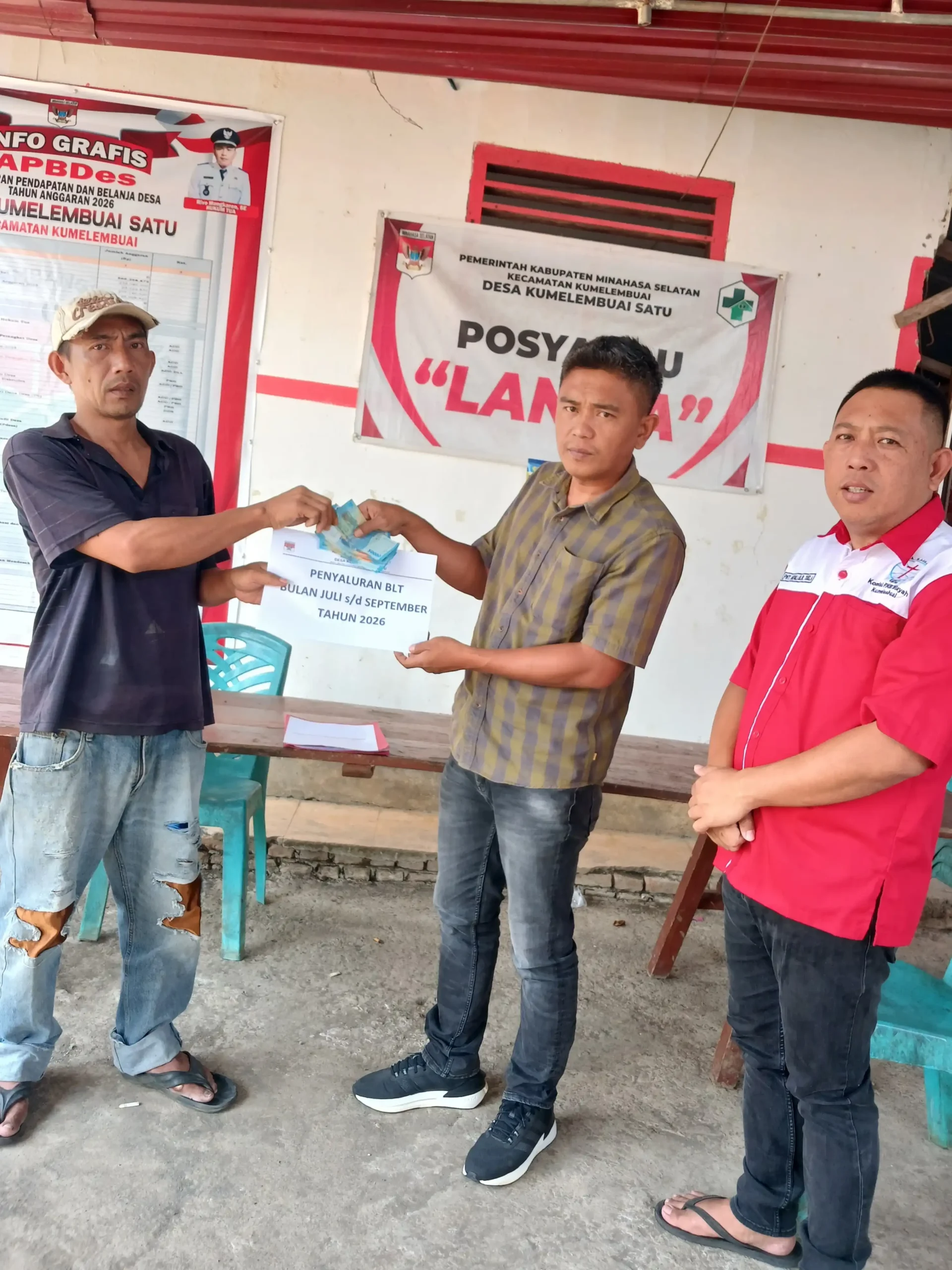 Penjabat Hukum Tua Desa Kumelembuai Satu Rivo Mongkaren SE saat menyerahkan BLT ke salah satu Keluarga Penerima Manfaat (KPM).