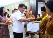 Gubernur Sulawesi Utara Mayjen TNI (Purn) Yulius Selvanus SE didampingi Ketua TP PKK Ny. Anik Yulius Selvanus menyerahkan penghargaan kepada pasangan keluarga harmonis di HUT ke-64 PWRI, Rabu (7/10/2026). (Foto: Istimewa)