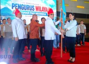 Ketum PB MPI, Dr. Sutia Budi, menyerahkan panji pataka kepada Ketua PW MPI Sulawesi Utara, Theresia Inggrid Manangka, dalam prosesi pengukuhan di Manado, Jumat (30/10/2026). Panji organisasi resmi dikibarkan untuk membumikan gerakan sosial dan kebudayaan di Bumi Nyiur Melambai. (Foto: Ridho L Tobing)